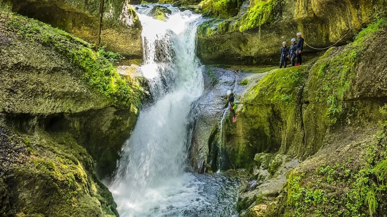 On saute depuis la grande cascade au soleil du canyon de Malvaux dans le Jura.