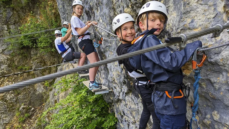 Groupe d'enfants sur le parcours ludique de la via ferrata de Morez dans le Jura.