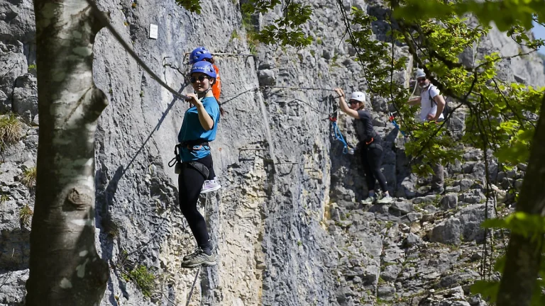 Traversée du pont de singe à la via ferrata de la Roche au Dade de Morez dans le Jura.