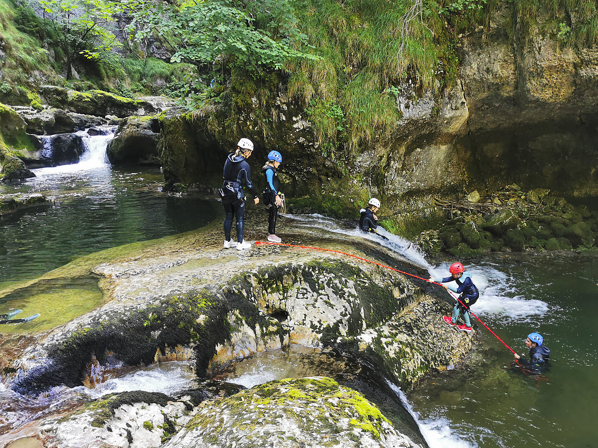 Une famille avec un enfant de 8 ans fait du canyoning dans le Jura. Les enfants s'amusent à glisser en tobogan avec la possibilité de remonter plusieurs fois.