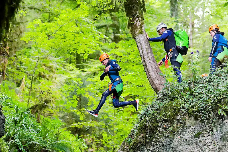 Une famille fait du canyoning dans le Jura sur un site ludique avec un toboggan très bien adapté aux enfants.